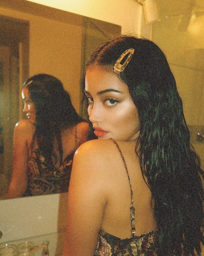 the rooms on fire and she’s fixing her hair @revolve...