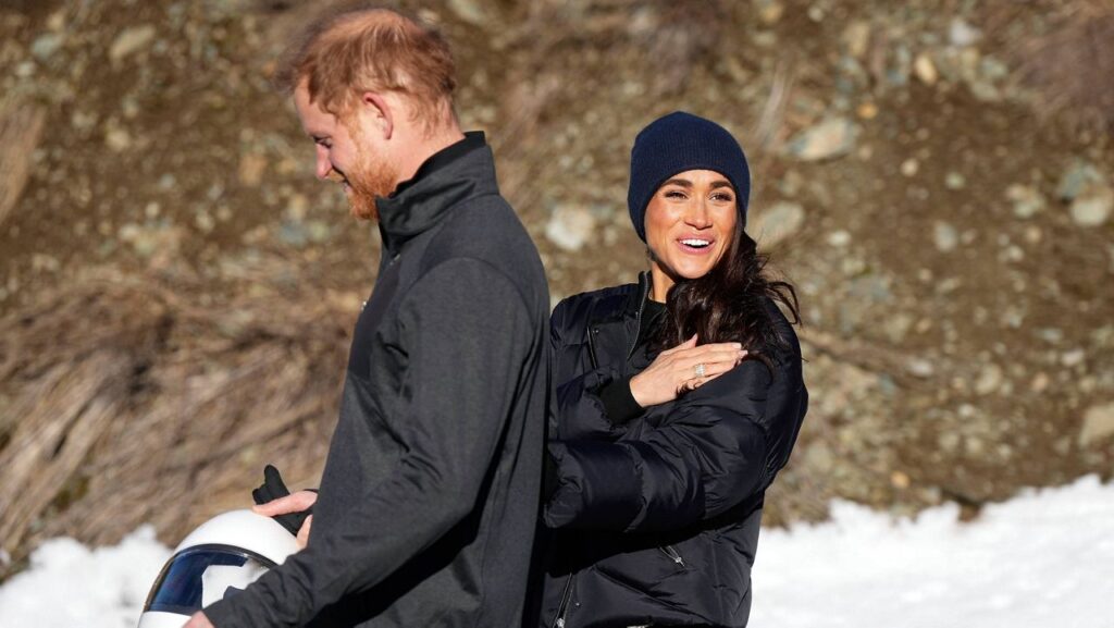 Britain's Prince Harry and Meghan, the Duke and Duchess of Sussex, walk together after Harry slid down the track on a skeleton sled a second time while attending an Invictus Games training camp, in Whistler, British Columbia, Thursday, Feb. 15, 2024. (Darryl Dyck/The Canadian Press via AP)