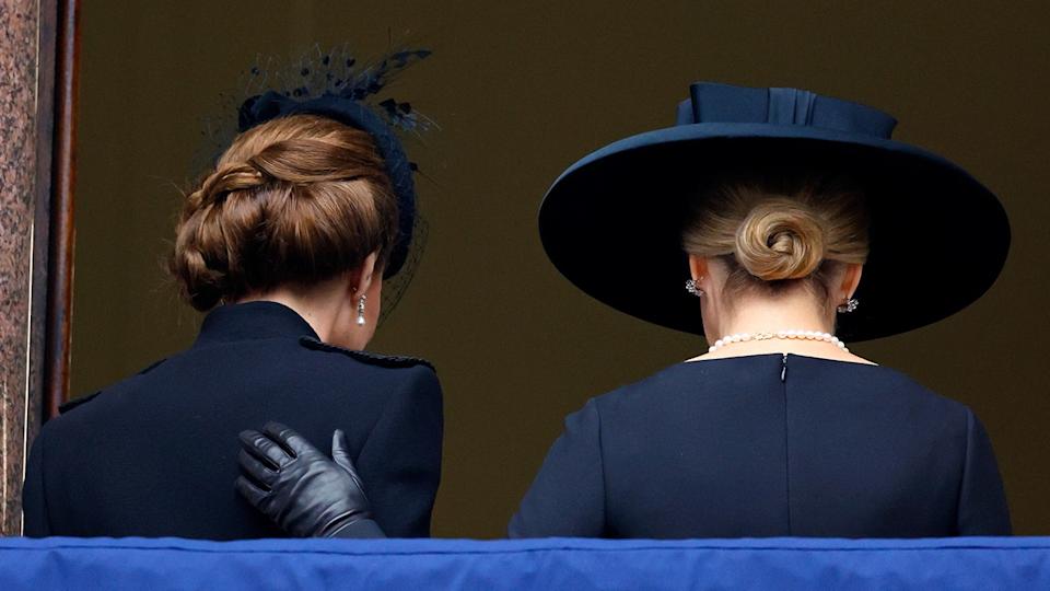 Kate Middleton and Sophie with their backs turned as Sophie puts her hand on Kate's back.