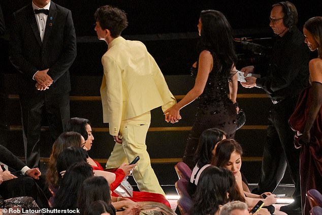 Timothee Chalamet and Kylie Jenner walk hand-in-hand through the Dolby Theatre during the Oscars telecast