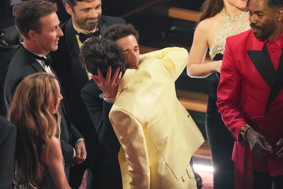 Adrien Brody, center left, embraces Timothée Chalamet