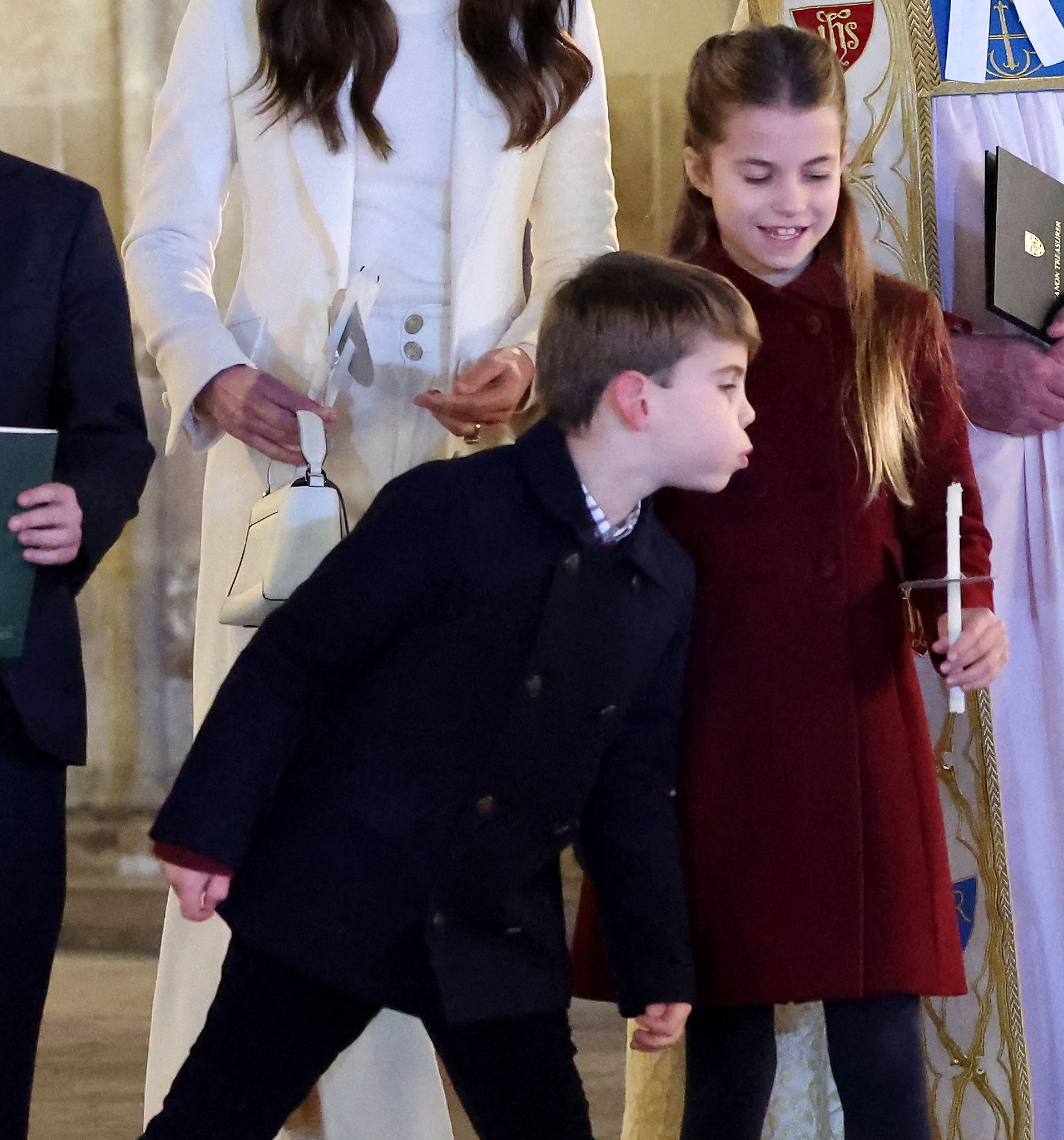 Prince Louis blowing out Princess Charlotte's candle at a Christmas carol service.