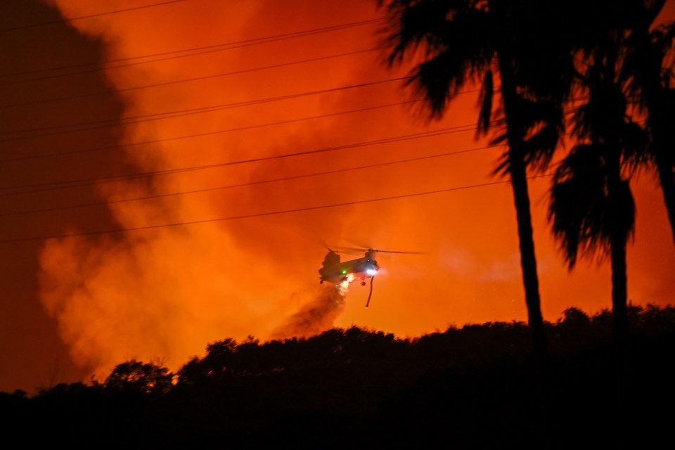 Helicopter dropping water on wildfire.