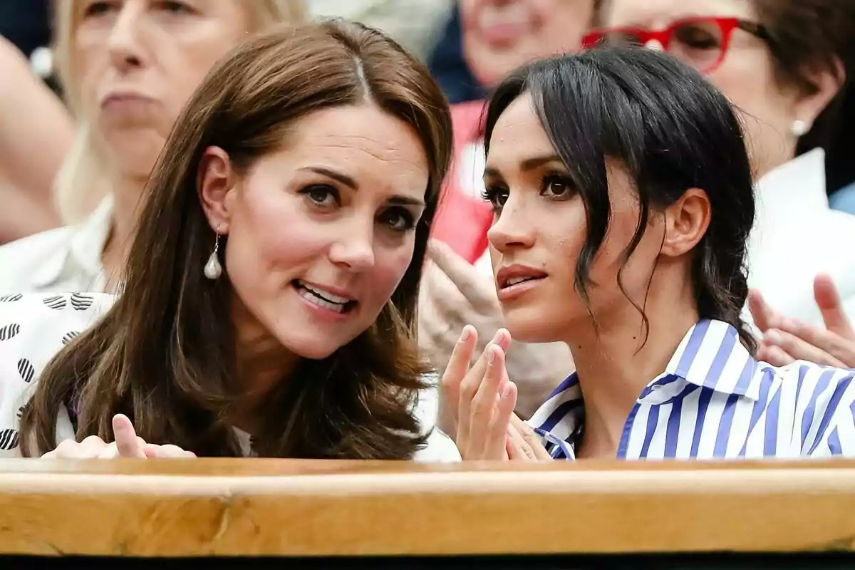 Kate Middleton and Meghan Markle chatting at a sporting event.