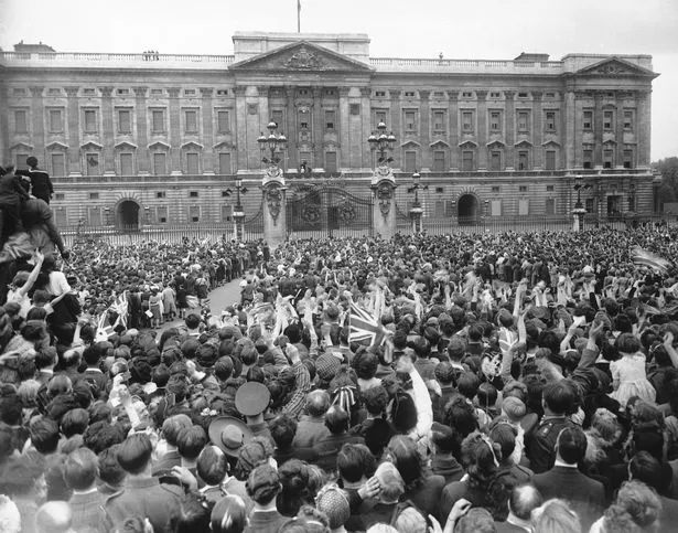 Crowds gather outside Buckingham Palace on VE Day before Princess Elizabeth joins them secretly