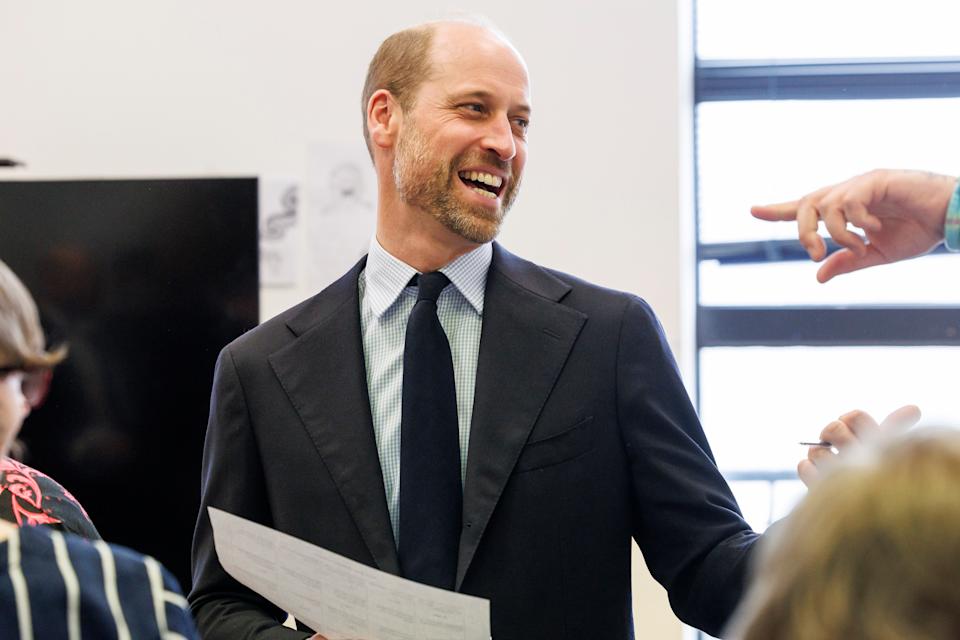 Prince William wearing a suit and tie smiling