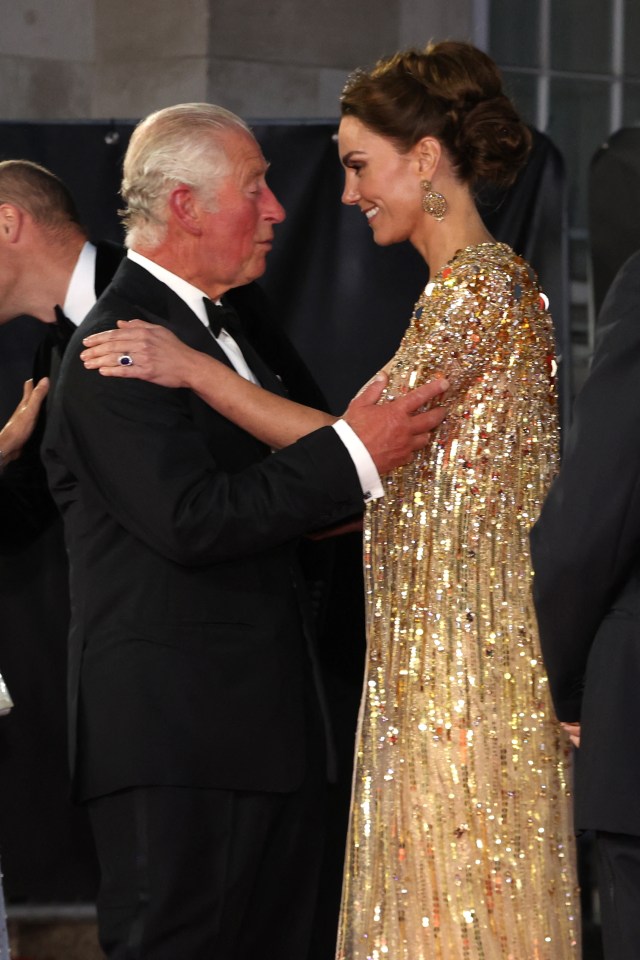 a man in a tuxedo and a woman in a gold dress are standing next to each other