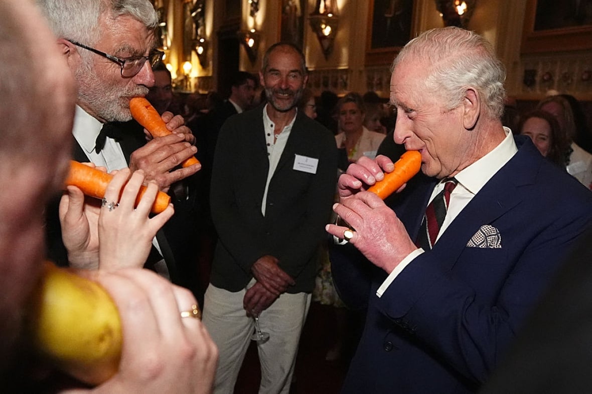 Several people hold vegetables that have been carved to create musical instruments to their mouths.