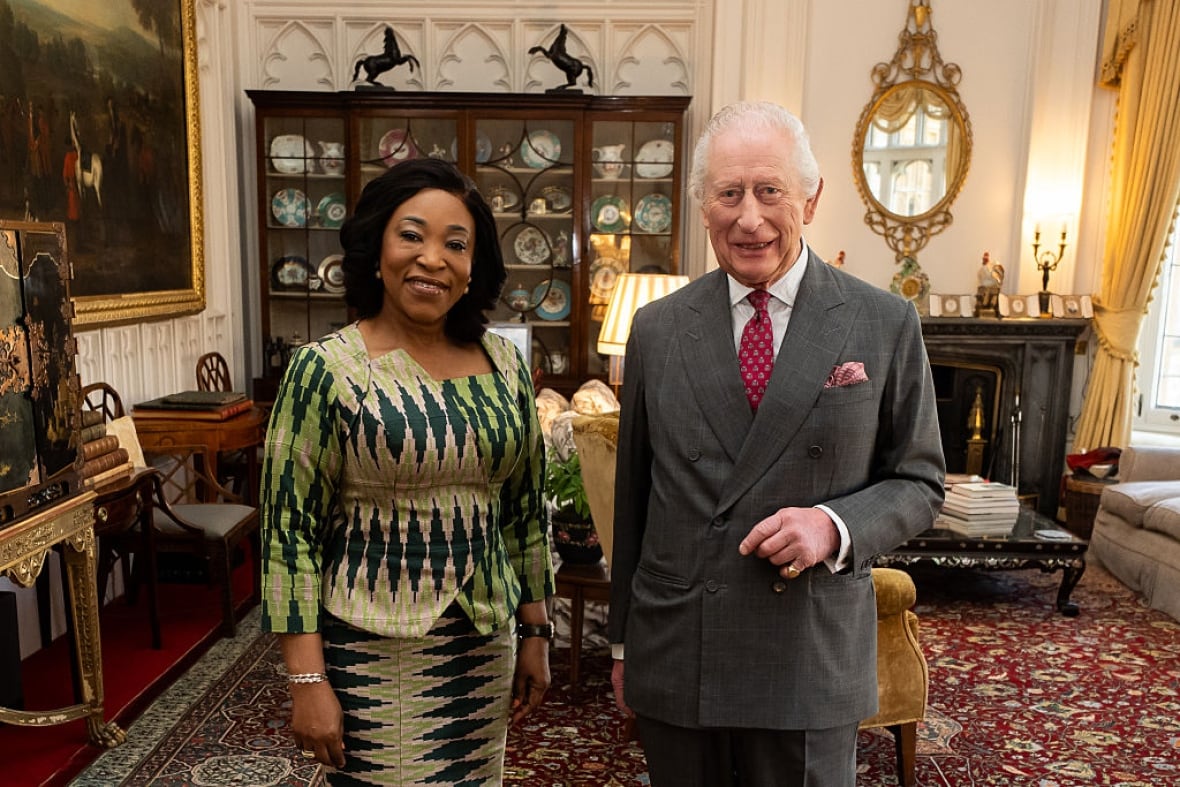 Two people stand in a large room.