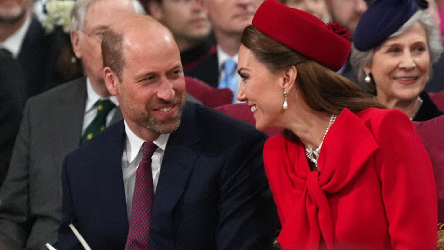 Kate Middleton and Prince William laughing and turning to smile at each other
