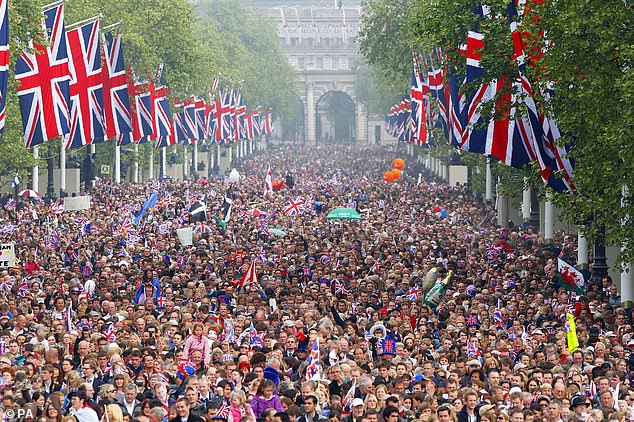 Crowds gather on the Mall outside Buckingham Palace on the couple's wedding day, waving union jacks