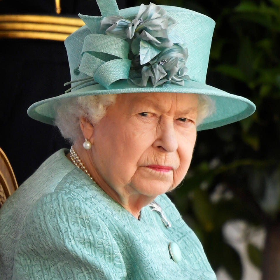  Queen Elizabeth glares while wearing a green suit and matching hat. 