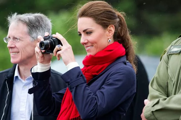 Catherine, Duchess of Cambridge takes photographs as Prince William, Duke of Cambridge takes part in helicopter manouvres called 'water birding' across Dalvay lake