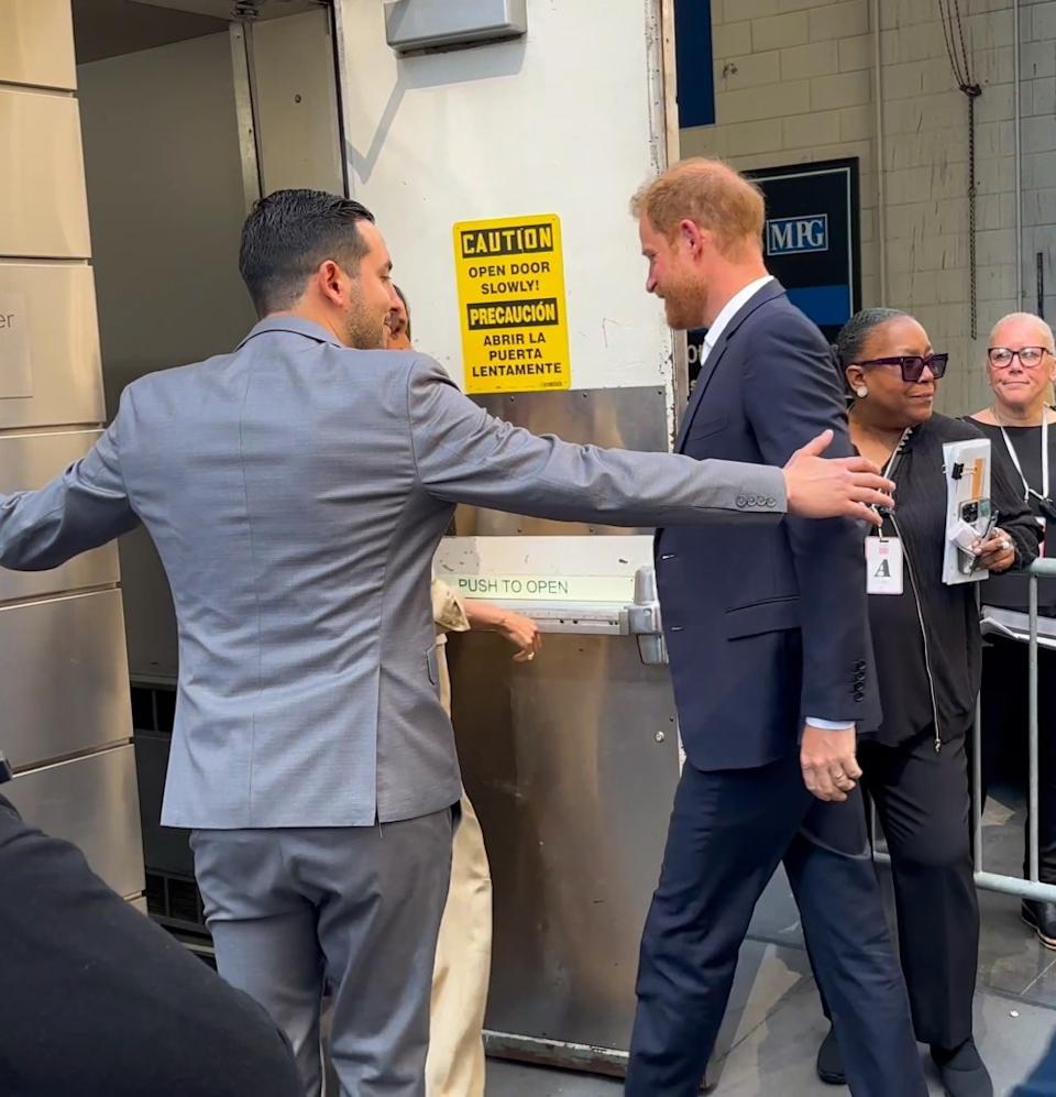 Prince Harry is ushered inside to the Time100 Summit with help from security. BACKGRID