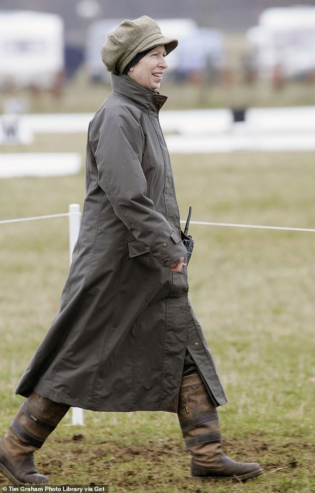 Catherine's style influencer, Princess Anne,  in a baker boy cap, Barbour style coat and waterproof boots strides through the mud on a rainy day at the British Eventing Gatcombe Horse Trials, 2006