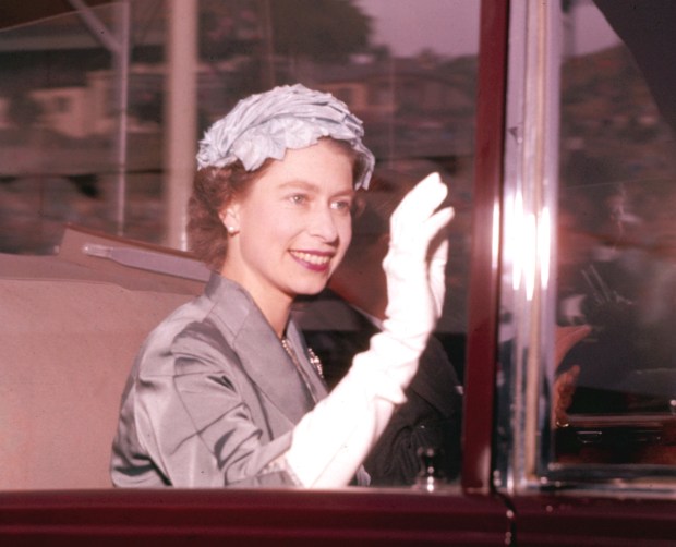 Britain’s Queen Elizabeth II waves to the crowd whilst travelling...