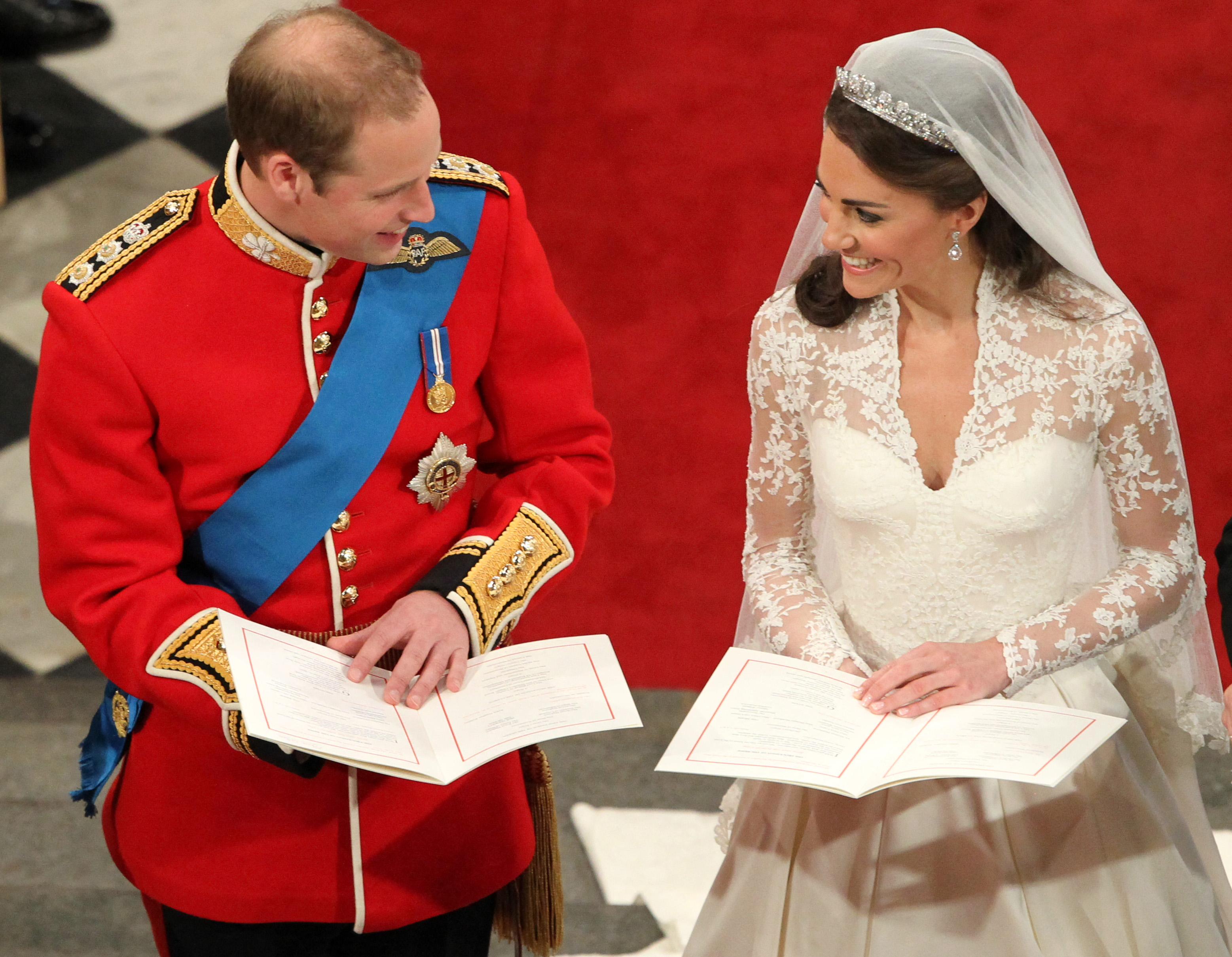 Kate Middleton and Prince William smiling at each other at their wedding