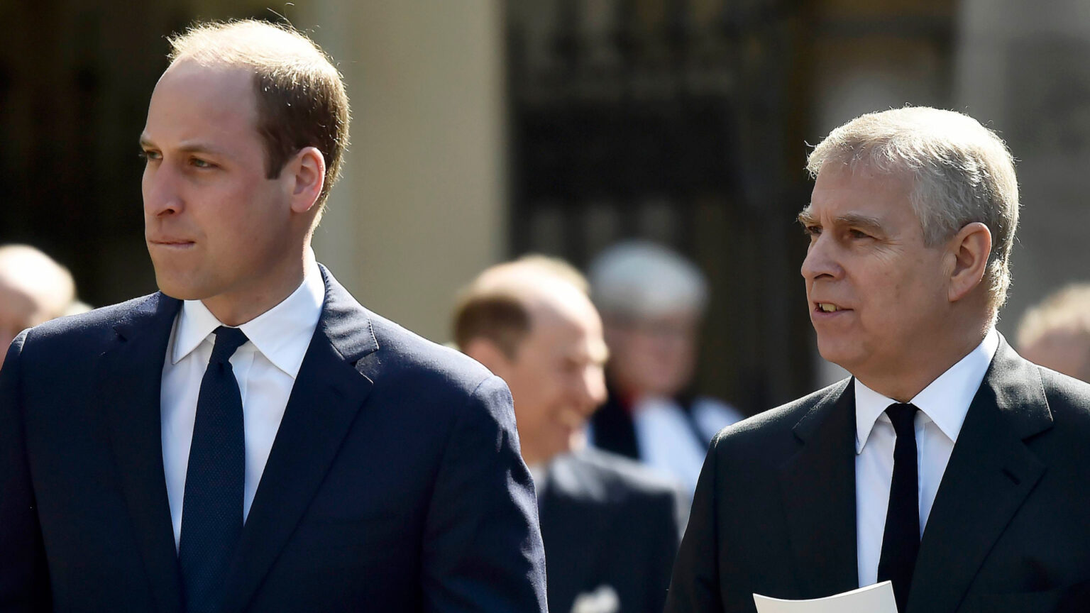 Prince William Has “No Time For” Uncle Prince Andrew, Per Royal Source Prince William and Prince Andrew wearing suits holding programs at a church service