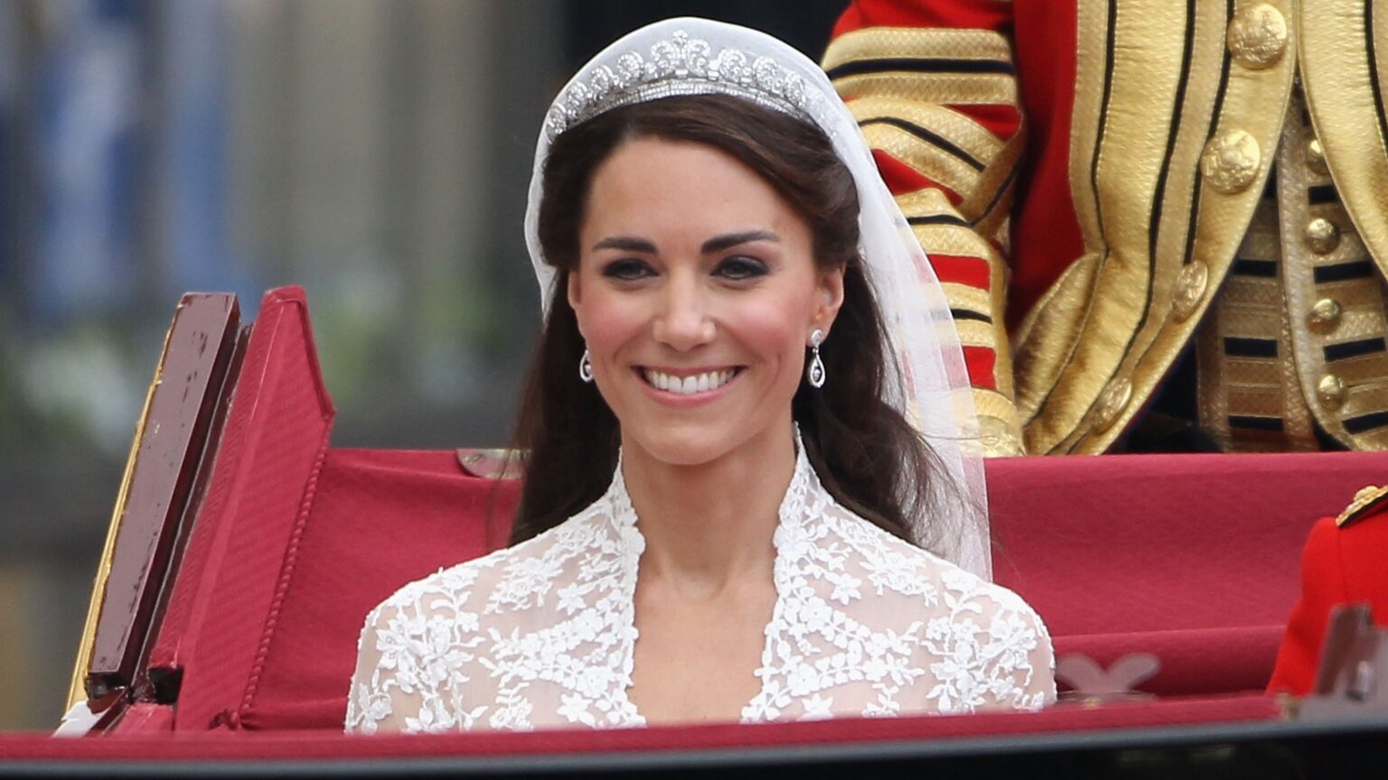 Catherine, Princess of Wales smiles as she journeys by carriage procession to Buckingham Palace following her marriage to Prince William