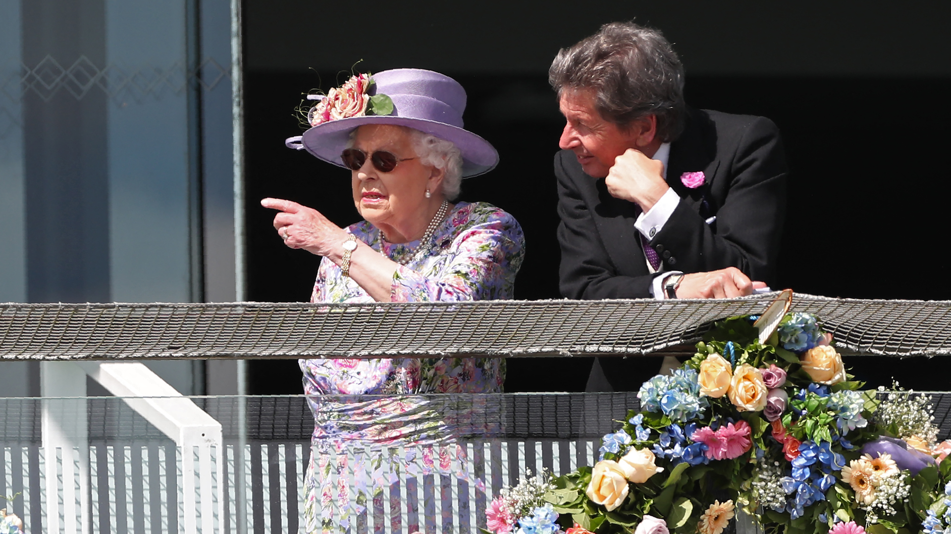 Britain's Queen Elizabeth II speaks with her racing manager John Warren on the second day of the Epsom Derby Festival in Surrey, southern England on June 2, 2018