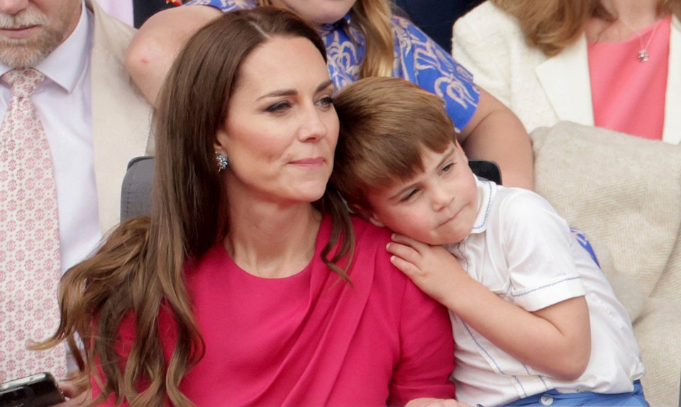 Prince Louis leaning on Kate, Duchess of Cambridge.