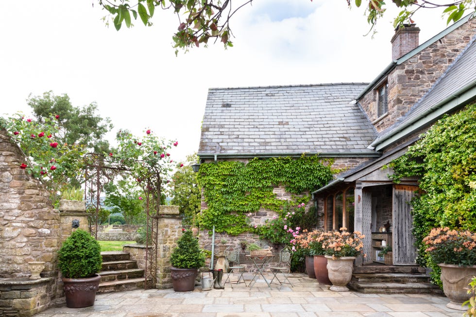 a house with a brick patio and a stone patio with plants and a brick wall and a brick