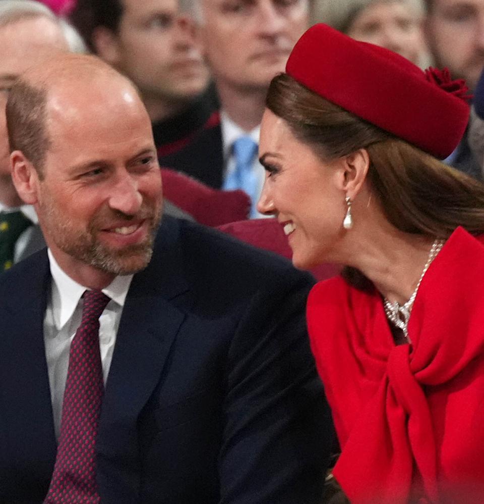  Kate Middleton and Prince William laughing and turning to smile at each other . 