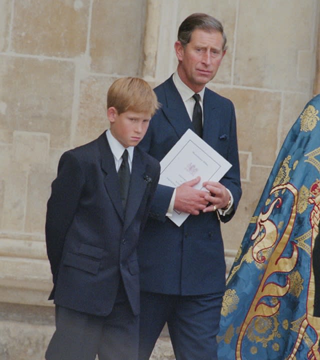 Prince Harry and the now King Charles holding something at Westminster Abbey for the funeral service of Princess Diana