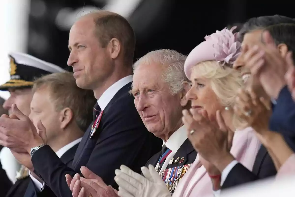 D-Day photo showing Prince William, King Charles III and Queen Camilla from the side, looking forward D-Day photo showing Prince William, King Charles III and Queen Camilla from the side, looking forward