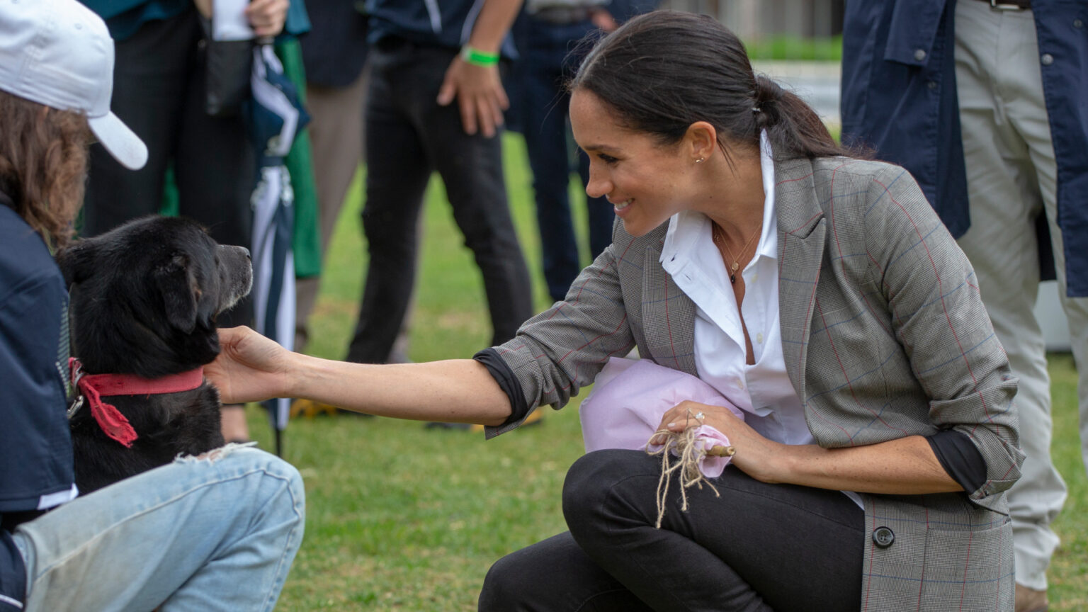 Meghan Markle wearing a gray blazer and black jeans in 2018