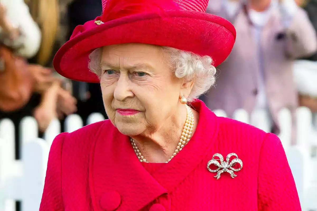 An elderly person with a hat and a red coat at an outdoor event. An elderly person with a hat and a red coat at an outdoor event.
