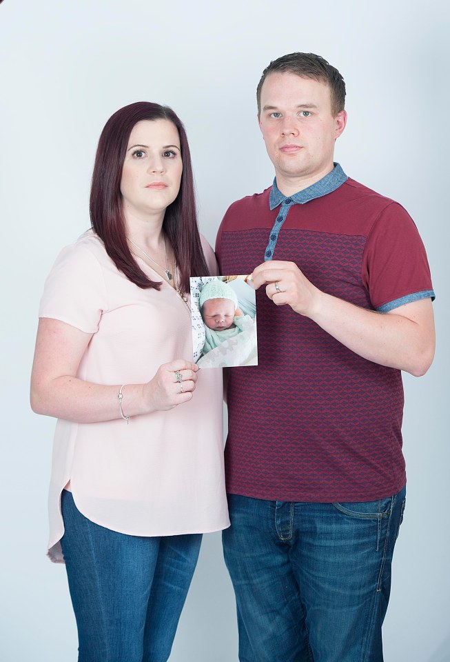 Parents holding a photo of their deceased baby.