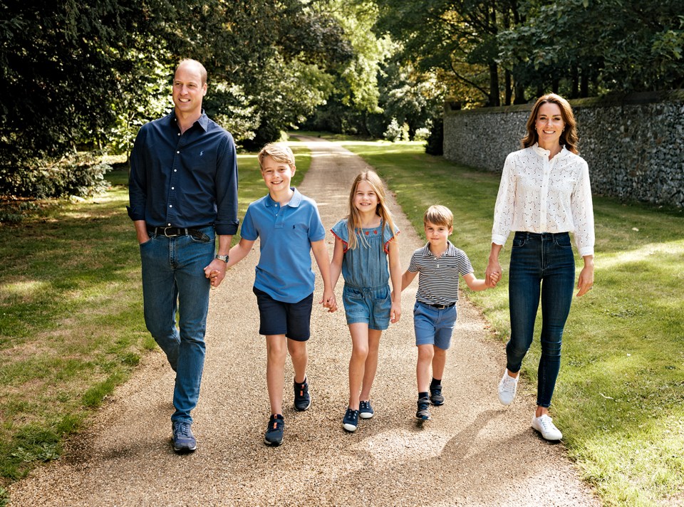 Photograph of Prince William, Princess Catherine, and their three children walking down a path.