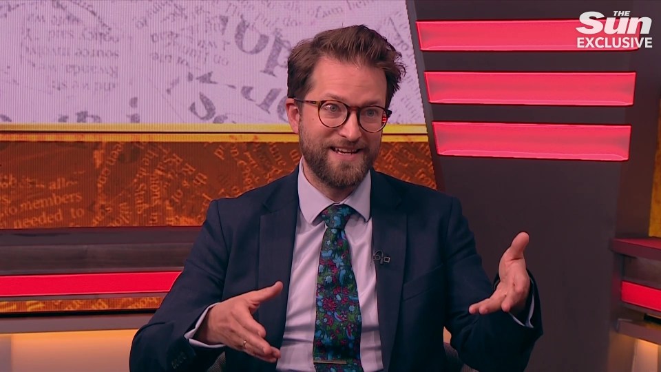 Man in suit speaking on television.