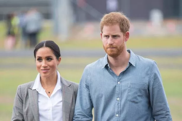 Meghan Markle and Prince Harry, walking hand-in-hand, in 2018.