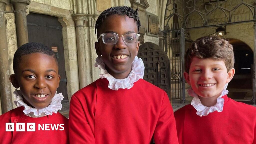 Three pre-teen boys smile into the camera from the cloisters of Westminster Abbey