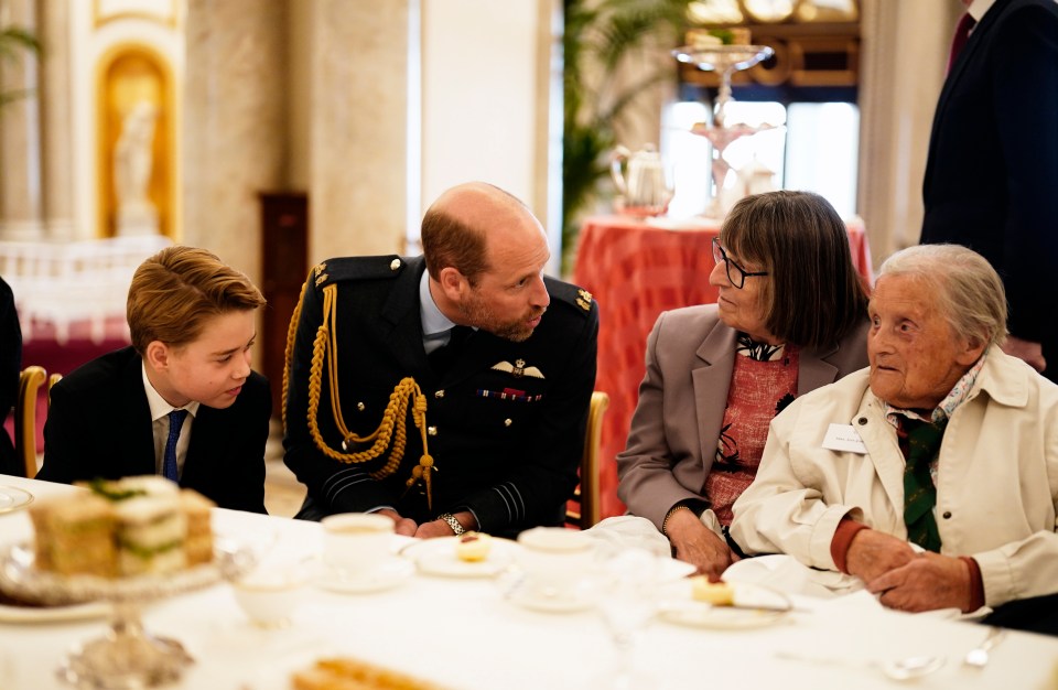 Prince William speaking with WWII veterans at a Buckingham Palace tea party.
