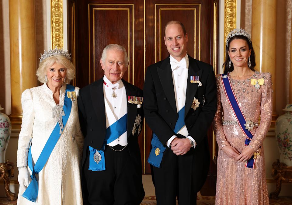 Queen Camilla, King Charles, Prince William and Princess Kate wearing gowns and tuxes and tiaras