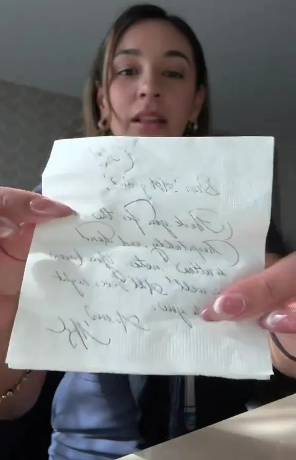Woman holding handwritten note.