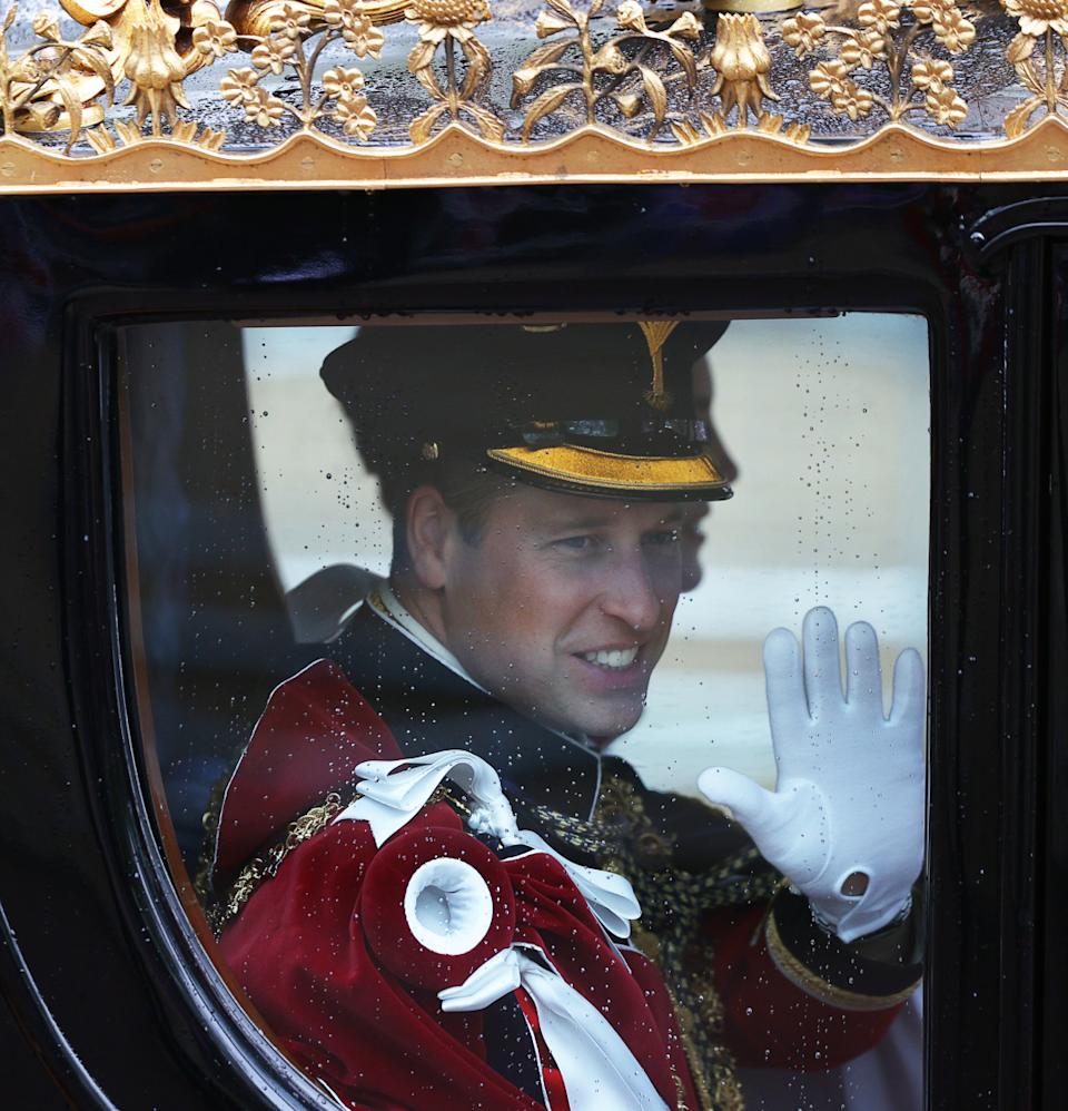  Prince William waving from a gold carriage at King Charles's coronation. 