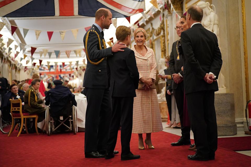 Prince William putting his arm around Prince George while talking to Duchess Sophie and Princess Kate