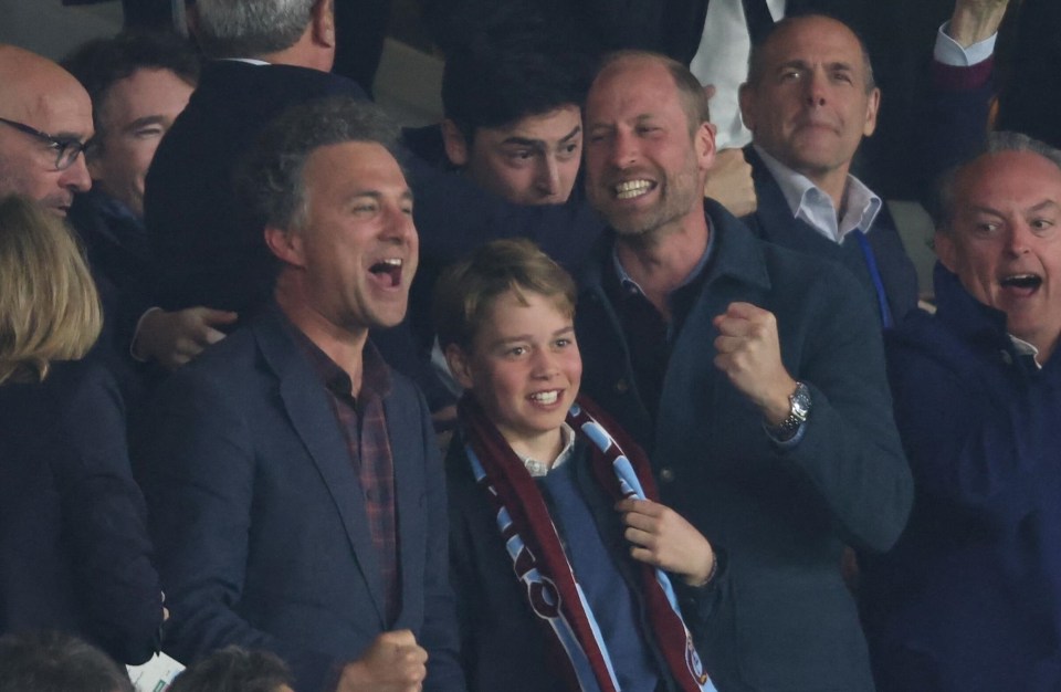 Prince William and Prince George celebrating a goal at a soccer match.