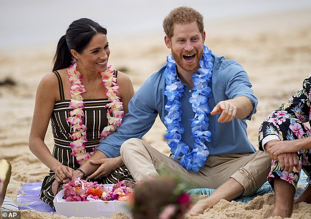 Meghan and Harry laugh with a local surfing group on Bondi Beach in 2018