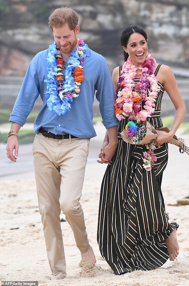 Prince Harry and Meghan Markle walk along Bondi Beach in Sydney, Australia, in 2018