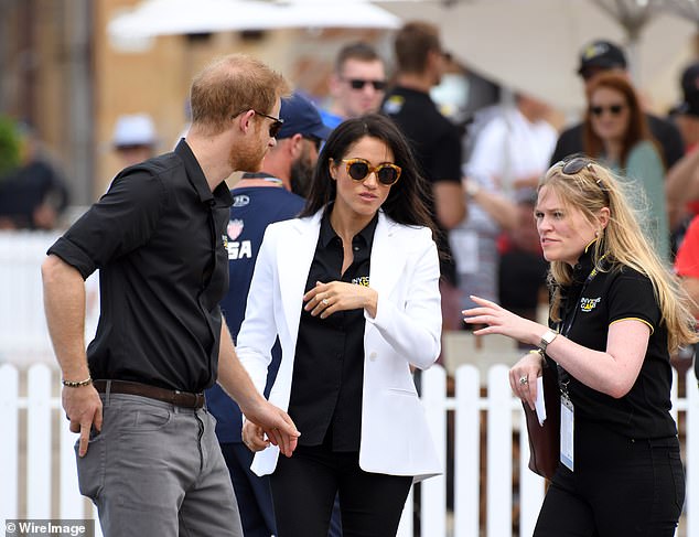 Prince Harry and  Meghan with her assistant Amy Pickerill in Sydney. A royal insider has revealed that behind the glittering success of the tour tensions were already starting to rise between the couple and their royal aides