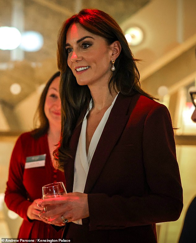 Kate wore Holland Cooper's versatile white shirt bodysuit under her tailored burgundy pantsuit at her Shaping Us symposium, also in 2023