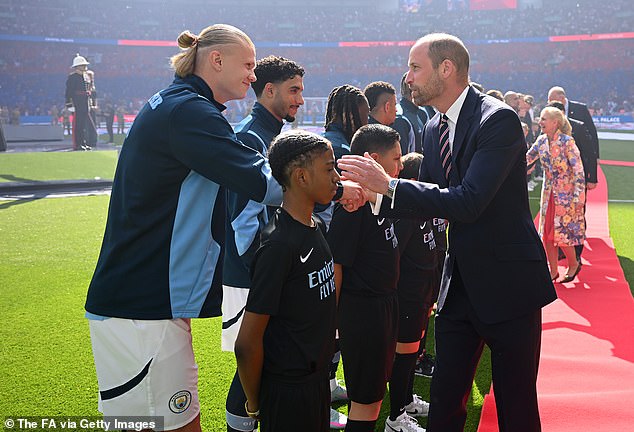 Pictured: Man City's Erling Haaland (left) smiles as he shakes hands with Prince William (right)