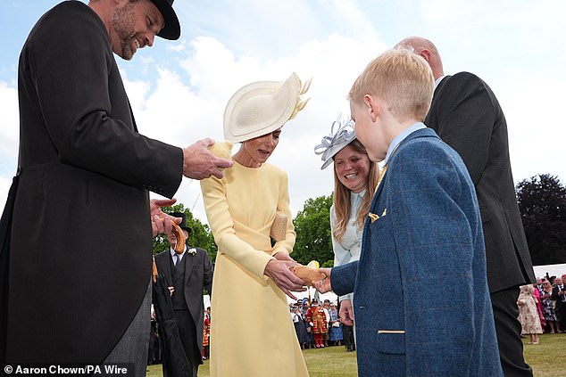 The Prince and Princess of Wales receive Jellycat soft toys and meet the family of Liz Hatton, mother Vicky Robayna, father Aaron and brother Mateo (pictured shaking Kate's hand)