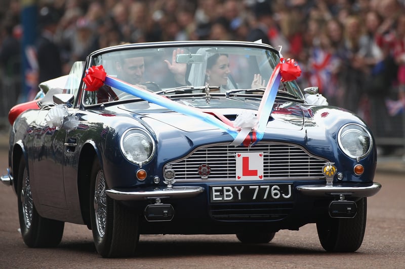 Prince William, Duke of Cambridge and Catherine, Duchess of Cambridge drive from Buckingham Palace in a decorated sports car on April 29, 2011 in London