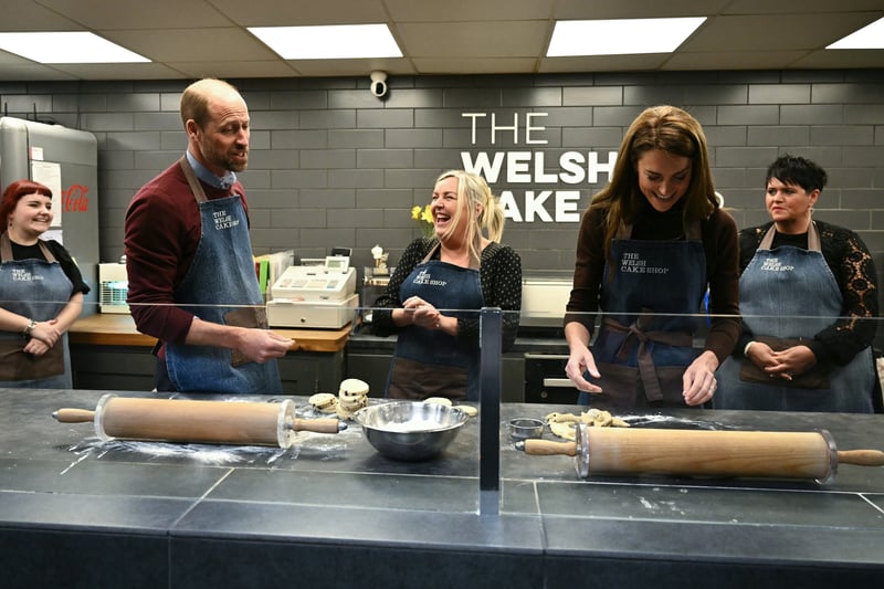Catherine, Princess of Wales and Prince William, Prince of Wales react as they make Welsh Cakes, watched by Theresa Connor, owner of the The Welsh Cake Shop during a visit to Pontypridd Market on February 26, 2025 in Pontypridd, Wales.